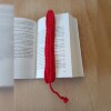 Handgehäkeltes Lesezeichen Rot aus feiner Baumwolle mit filigraner Häkelstruktur und handgeflochtenem Abschlussband. Etwa 2 x 25 cm groß, flach und leicht, ideal zum Markieren von Buchseiten, ohne das Buch zu beschädigen. In verschiedenen Farben erhältlich – jedes Stück ein handgefertigtes Unikat für stilvolles, liebevolles Lesen.