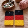 Handgehäkelte Handyhülle Deutschland Handyhülle in den Farben Schwarz, Rot und Gold, angeordnet wie die deutsche Flagge. Aus robustem Wollgarn gefertigt, mit weicher Struktur und sicherem Knopfverschluss oben. Schützt das Smartphone vor Kratzern und Stößen. Erhältlich in zwei Größen – ein handgemachtes Accessoire für Fans und Liebhaber deutscher Farben.