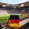 Handgehäkelte Tasche Deutschland Tasche in den Farben Schwarz, Rot und Gold, inspiriert von der deutschen Flagge. Mit breitem, verstellbarem Schultergurt, stabilem Kordelzugverschluss und dekorativem Kordelende. Etwa 19 x 26 cm groß, bietet Platz für Alltagsutensilien wie Handy, Geldbörse und Schlüssel. Stilvolles, handgemachtes Accessoire für Fans und Liebhaber deutscher Farben.