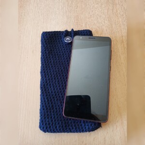 Handgehäkelte Handyhülle Dunkelblau aus weicher, strapazierfähiger Baumwolle mit dekorativem Knopfverschluss. Etwa 10 x 18 cm groß, dehnbar und passend für viele Smartphone-Modelle. Schützt das Handy vor Kratzern und leichten Stößen, handgefertigt in verschiedenen Farben – jedes Stück ein individuelles Unikat mit liebevollen Details.