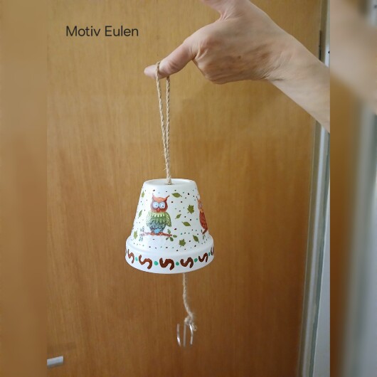 Handbemalte Futterglocke Motiv Eulen aus einem Tontopf, bunt verziert mit Serviettentechnik, hängt an einer dicken Kordel. Im Inneren ist ein Metallhaken für Vogelfutter angebracht. Dekorative Winterfütterung für kleine Gartenvögel.
