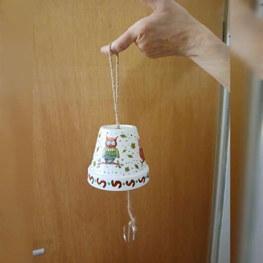 Handbemalte Futterglocke Motiv Eulen aus einem Tontopf, bunt verziert mit Serviettentechnik, hängt an einer dicken Kordel. Im Inneren ist ein Metallhaken für Vogelfutter angebracht. Dekorative Winterfütterung für kleine Gartenvögel.