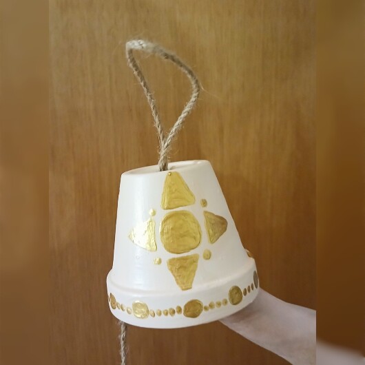 Handbemalte Futterglocke Motiv Gold aus einem Tontopf, bunt verziert mit Serviettentechnik, hängt an einer dicken Kordel. Im Inneren ist ein Metallhaken für Vogelfutter angebracht. Dekorative Winterfütterung für kleine Gartenvögel.