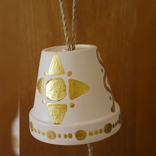 Handbemalte Futterglocke Motiv Gold aus einem Tontopf, bunt verziert mit Serviettentechnik, hängt an einer dicken Kordel. Im Inneren ist ein Metallhaken für Vogelfutter angebracht. Dekorative Winterfütterung für kleine Gartenvögel.