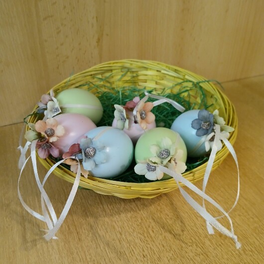 Handgemachte Ostereier in sanften Pastellfarben wie Rosa, Hellblau und Mintgrün, jeweils mit weißen Satinbändern und kleinen, farblich abgestimmten Blütenapplikationen verziert. Die Eier haben eine leicht schimmernde Oberfläche und hängen an eleganten Satinbändern. Die zarten Blüten und weichen Farben verleihen der Osterdeko einen eleganten, frühlingshaften und verspielten Look.