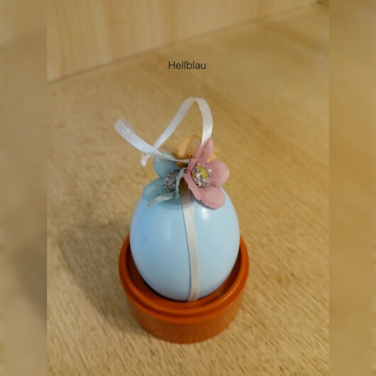 Handgemachte Ostereier in sanften Pastellfarben wie Rosa, Hellblau und Mintgrün, jeweils mit weißen Satinbändern und kleinen, farblich abgestimmten Blütenapplikationen verziert. Die Eier haben eine leicht schimmernde Oberfläche und hängen an eleganten Satinbändern. Die zarten Blüten und weichen Farben verleihen der Osterdeko einen eleganten, frühlingshaften und verspielten Look.