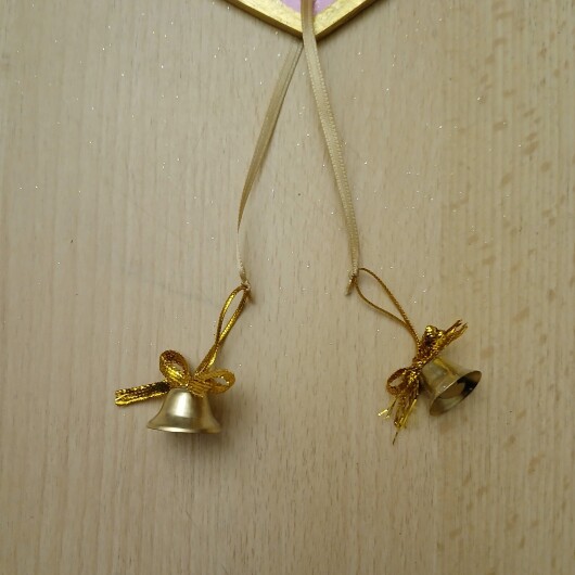 Handbemaltes Herz Türschild Pink-Gold aus Holz, verziert mit kleinen goldenen und silbernen Glöckchen. Das dekorative Herz hängt an einer Schnur und erzeugt bei Bewegung ein leises Klingeln. Es wirkt warm, einladend und eignet sich ideal als Tür- oder Wanddeko für Zuhause, zum Valentinstag oder als liebevolles Geschenk.