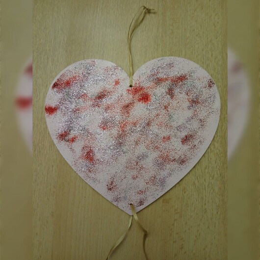 Handbemaltes Herz Türschild Rosa-Glitzer aus Holz, verziert mit kleinen goldenen und silbernen Glöckchen. Das dekorative Herz hängt an einer Schnur und erzeugt bei Bewegung ein leises Klingeln. Es wirkt warm, einladend und eignet sich ideal als Tür- oder Wanddeko für Zuhause, zum Valentinstag oder als liebevolles Geschenk.