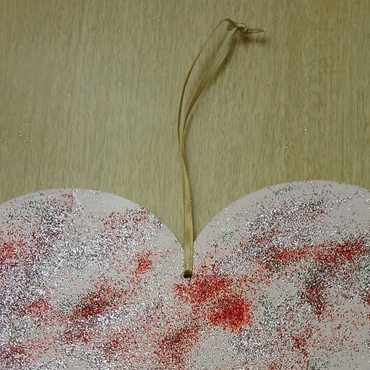 Handbemaltes Herz Türschild Rosa-Glitzer aus Holz, verziert mit kleinen goldenen und silbernen Glöckchen. Das dekorative Herz hängt an einer Schnur und erzeugt bei Bewegung ein leises Klingeln. Es wirkt warm, einladend und eignet sich ideal als Tür- oder Wanddeko für Zuhause, zum Valentinstag oder als liebevolles Geschenk.