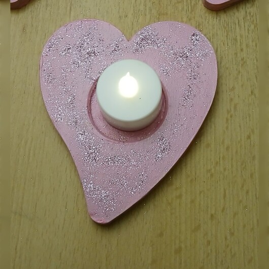 Handbemalte Herz Teelichthalter Rosa aus Holz im 4er Set, jeweils mit farbenfrohen, individuellen Designs. In der Mitte jedes Herzens befindet sich eine Vertiefung für ein kleines Teelicht, das warmes Licht auf das bemalte Holz wirft. Das 4er-Set strahlt Gemütlichkeit und Liebe aus – perfekt als romantische Deko, Geschenk oder Lichtakzent für Valentinstag, Hochzeit oder Alltag.