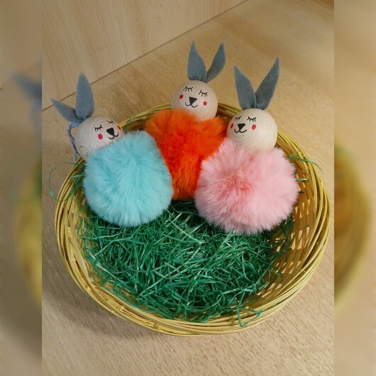 Handgefertigte Pompon-Osterhäschen aus weichem, flauschigem Material in fröhlichen Farben wie Rosa, Gelb, Hellblau, Weiß und Dunkelgrün. Jedes Häschen hat lange graue Filzohren, handbemalte Augen, Nase und rosige Wangen sowie eine graue Aufhängeschlaufe. Die niedlichen Anhänger verbreiten frühlingshafte Osterstimmung an Zweigen, Fenstern oder Geschenken.