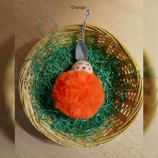 Handgefertigte Pompon-Osterhäschen Orange aus weichem, flauschigem Material in fröhlichen Farben wie Rosa, Gelb, Hellblau, Weiß und Dunkelgrün. Jedes Häschen hat lange graue Filzohren, handbemalte Augen, Nase und rosige Wangen sowie eine graue Aufhängeschlaufe. Die niedlichen Anhänger verbreiten frühlingshafte Osterstimmung an Zweigen, Fenstern oder Geschenken.