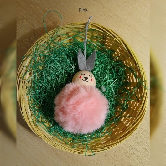 Handgefertigte Pompon-Osterhäschen Pink aus weichem, flauschigem Material in fröhlichen Farben wie Rosa, Gelb, Hellblau, Weiß und Dunkelgrün. Jedes Häschen hat lange graue Filzohren, handbemalte Augen, Nase und rosige Wangen sowie eine graue Aufhängeschlaufe. Die niedlichen Anhänger verbreiten frühlingshafte Osterstimmung an Zweigen, Fenstern oder Geschenken.