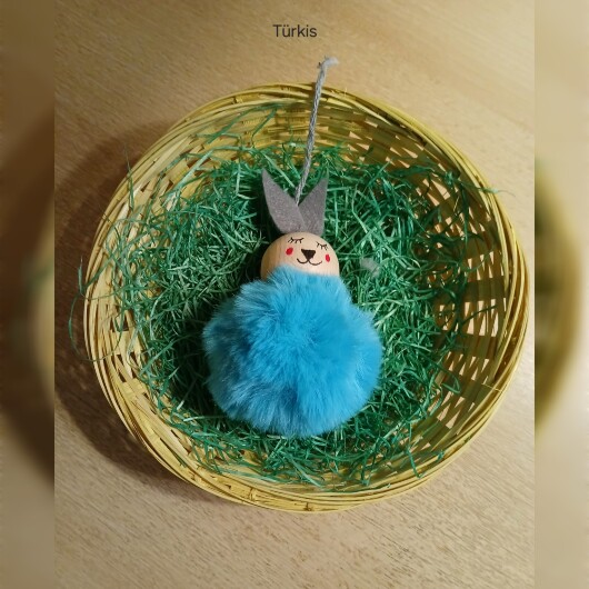 Handgefertigte Pompon-Osterhäschen Türkis aus weichem, flauschigem Material in fröhlichen Farben wie Rosa, Gelb, Hellblau, Weiß und Dunkelgrün. Jedes Häschen hat lange graue Filzohren, handbemalte Augen, Nase und rosige Wangen sowie eine graue Aufhängeschlaufe. Die niedlichen Anhänger verbreiten frühlingshafte Osterstimmung an Zweigen, Fenstern oder Geschenken.