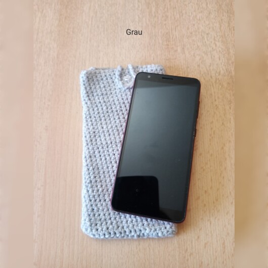Handgehäkelte Handyhülle Grau aus weicher, strapazierfähiger Baumwolle mit dekorativem Knopfverschluss. Etwa 10 x 18 cm groß, dehnbar und passend für viele Smartphone-Modelle. Schützt das Handy vor Kratzern und leichten Stößen, handgefertigt in verschiedenen Farben – jedes Stück ein individuelles Unikat mit liebevollen Details.