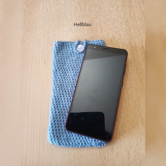 Handgehäkelte Handyhülle Hellblau aus weicher, strapazierfähiger Baumwolle mit dekorativem Knopfverschluss. Etwa 10 x 18 cm groß, dehnbar und passend für viele Smartphone-Modelle. Schützt das Handy vor Kratzern und leichten Stößen, handgefertigt in verschiedenen Farben – jedes Stück ein individuelles Unikat mit liebevollen Details.