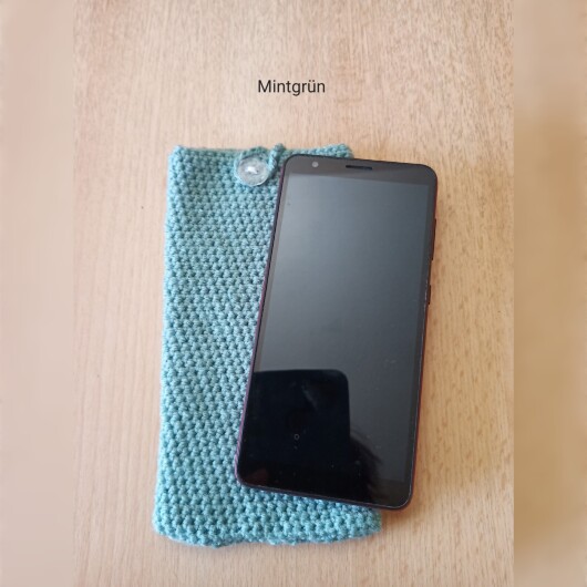 Handgehäkelte Handyhülle Mintgrün aus weicher, strapazierfähiger Baumwolle mit dekorativem Knopfverschluss. Etwa 10 x 18 cm groß, dehnbar und passend für viele Smartphone-Modelle. Schützt das Handy vor Kratzern und leichten Stößen, handgefertigt in verschiedenen Farben – jedes Stück ein individuelles Unikat mit liebevollen Details.