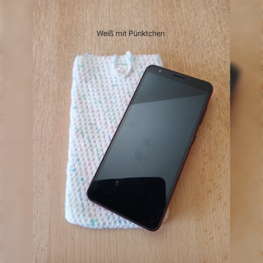 Handgehäkelte Handyhülle Weiß mit Pünktchen aus weicher, strapazierfähiger Baumwolle mit dekorativem Knopfverschluss. Etwa 10 x 18 cm groß, dehnbar und passend für viele Smartphone-Modelle. Schützt das Handy vor Kratzern und leichten Stößen, handgefertigt in verschiedenen Farben – jedes Stück ein individuelles Unikat mit liebevollen Details.