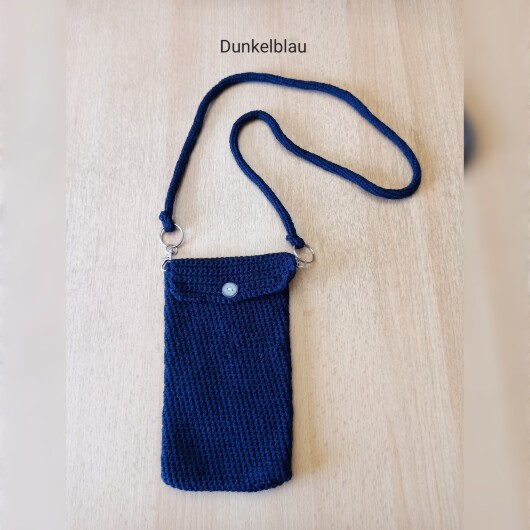Handgehäkelte Handytasche Dunkelblau aus hochwertigem Garn mit gleichmäßiger Struktur und Knopfverschluss. Die Tasche misst etwa 12 x 20 cm, bietet Platz für ein Smartphone und kleine Alltagsgegenstände. Mit abnehmbarem Schultergurt, der wahlweise als Umhängetasche oder Handyhülle genutzt werden kann. In verschiedenen Farben erhältlich – ein handgemachtes, stilvolles und nachhaltiges Accessoire.