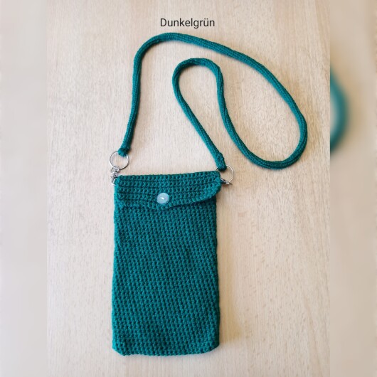 Handgehäkelte Handytasche Dunkelgrün aus hochwertigem Garn mit gleichmäßiger Struktur und Knopfverschluss. Die Tasche misst etwa 12 x 20 cm, bietet Platz für ein Smartphone und kleine Alltagsgegenstände. Mit abnehmbarem Schultergurt, der wahlweise als Umhängetasche oder Handyhülle genutzt werden kann. In verschiedenen Farben erhältlich – ein handgemachtes, stilvolles und nachhaltiges Accessoire.