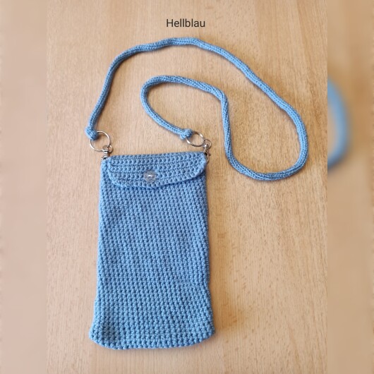 Handgehäkelte Handytasche Hellblau aus hochwertigem Garn mit gleichmäßiger Struktur und Knopfverschluss. Die Tasche misst etwa 12 x 20 cm, bietet Platz für ein Smartphone und kleine Alltagsgegenstände. Mit abnehmbarem Schultergurt, der wahlweise als Umhängetasche oder Handyhülle genutzt werden kann. In verschiedenen Farben erhältlich – ein handgemachtes, stilvolles und nachhaltiges Accessoire.