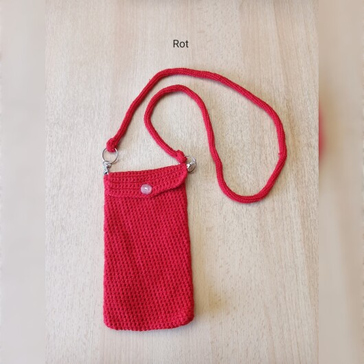 Handgehäkelte Handytasche Rot aus hochwertigem Garn mit gleichmäßiger Struktur und Knopfverschluss. Die Tasche misst etwa 12 x 20 cm, bietet Platz für ein Smartphone und kleine Alltagsgegenstände. Mit abnehmbarem Schultergurt, der wahlweise als Umhängetasche oder Handyhülle genutzt werden kann. In verschiedenen Farben erhältlich – ein handgemachtes, stilvolles und nachhaltiges Accessoire.