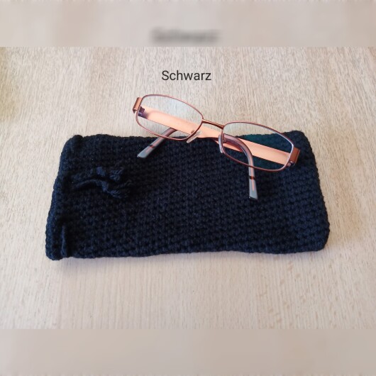 Handgehäkeltes Brillenetui Schwarz aus weicher Baumwolle mit handgeflochtenem Kordelzug. Das etwa 9 x 20 cm große Etui bietet Platz für Lese-, Sonnen- oder Sehbrillen und schützt sie zuverlässig vor Kratzern und leichten Stößen. Leichtes, schlankes Design mit rustikalem Charme – in verschiedenen Farben erhältlich, handgefertigt und nachhaltig hergestellt.