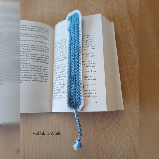Handgehäkeltes Lesezeichen Hellblau-Weiß aus feiner Baumwolle mit filigraner Häkelstruktur und handgeflochtenem Abschlussband. Etwa 2 x 25 cm groß, flach und leicht, ideal zum Markieren von Buchseiten, ohne das Buch zu beschädigen. In verschiedenen Farben erhältlich – jedes Stück ein handgefertigtes Unikat für stilvolles, liebevolles Lesen.