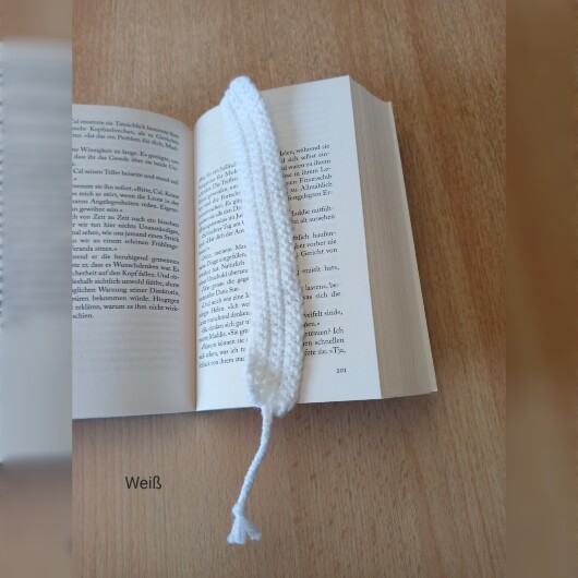 Handgehäkeltes Lesezeichen Weiß aus feiner Baumwolle mit filigraner Häkelstruktur und handgeflochtenem Abschlussband. Etwa 2 x 25 cm groß, flach und leicht, ideal zum Markieren von Buchseiten, ohne das Buch zu beschädigen. In verschiedenen Farben erhältlich – jedes Stück ein handgefertigtes Unikat für stilvolles, liebevolles Lesen.