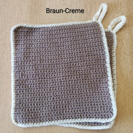 Handgehäkeltes Topflappen-Set Braun-Creme aus robustem Baumwollgarn, quadratisch mit ca. 16 x 16 cm Größe. Die gleichmäßige Häkelstruktur sorgt für Hitzeschutz beim Kochen und Backen. Jeder Topflappen hat eine stabile Aufhängeschlaufe und ist wahlweise einfarbig oder mit farbigem Rand gestaltet – ein dekorativer, funktionaler Küchenhelfer in Handarbeit.