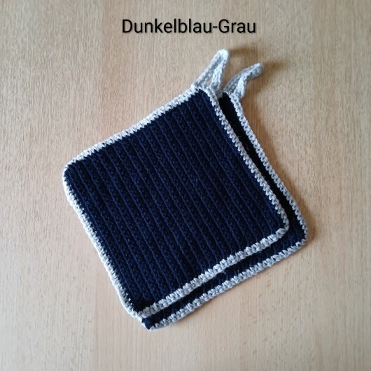 Handgehäkeltes Topflappen-Set Dunkelblau-Grau aus robustem Baumwollgarn, quadratisch mit ca. 16 x 16 cm Größe. Die gleichmäßige Häkelstruktur sorgt für Hitzeschutz beim Kochen und Backen. Jeder Topflappen hat eine stabile Aufhängeschlaufe und ist wahlweise einfarbig oder mit farbigem Rand gestaltet – ein dekorativer, funktionaler Küchenhelfer in Handarbeit.