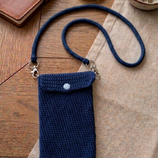 Handgehäkelte Handytasche Gehäkelte Umhängetasche aus hochwertigem Garn mit gleichmäßiger Struktur und Knopfverschluss. Die Tasche misst etwa 12 x 20 cm, bietet Platz für ein Smartphone und kleine Alltagsgegenstände. Mit abnehmbarem Schultergurt, der wahlweise als Umhängetasche oder Handyhülle genutzt werden kann. In verschiedenen Farben erhältlich – ein handgemachtes, stilvolles und nachhaltiges Accessoire.