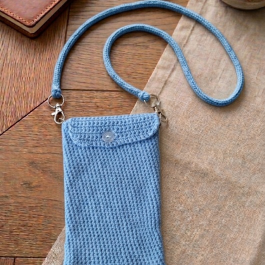 Handgehäkelte Handytasche Gehäkelte Umhängetasche aus hochwertigem Garn mit gleichmäßiger Struktur und Knopfverschluss. Die Tasche misst etwa 12 x 20 cm, bietet Platz für ein Smartphone und kleine Alltagsgegenstände. Mit abnehmbarem Schultergurt, der wahlweise als Umhängetasche oder Handyhülle genutzt werden kann. In verschiedenen Farben erhältlich – ein handgemachtes, stilvolles und nachhaltiges Accessoire.