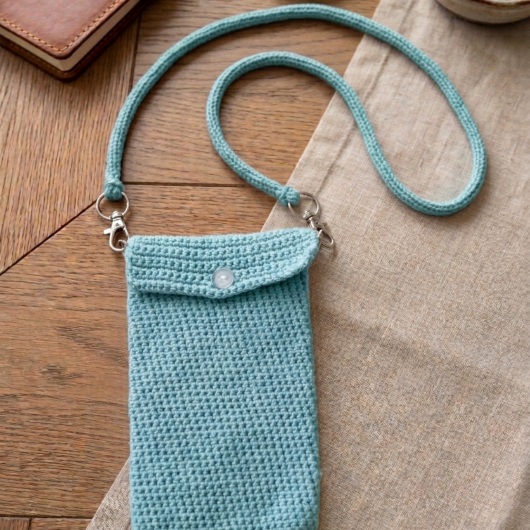 Handgehäkelte Handytasche Gehäkelte Umhängetasche aus hochwertigem Garn mit gleichmäßiger Struktur und Knopfverschluss. Die Tasche misst etwa 12 x 20 cm, bietet Platz für ein Smartphone und kleine Alltagsgegenstände. Mit abnehmbarem Schultergurt, der wahlweise als Umhängetasche oder Handyhülle genutzt werden kann. In verschiedenen Farben erhältlich – ein handgemachtes, stilvolles und nachhaltiges Accessoire.